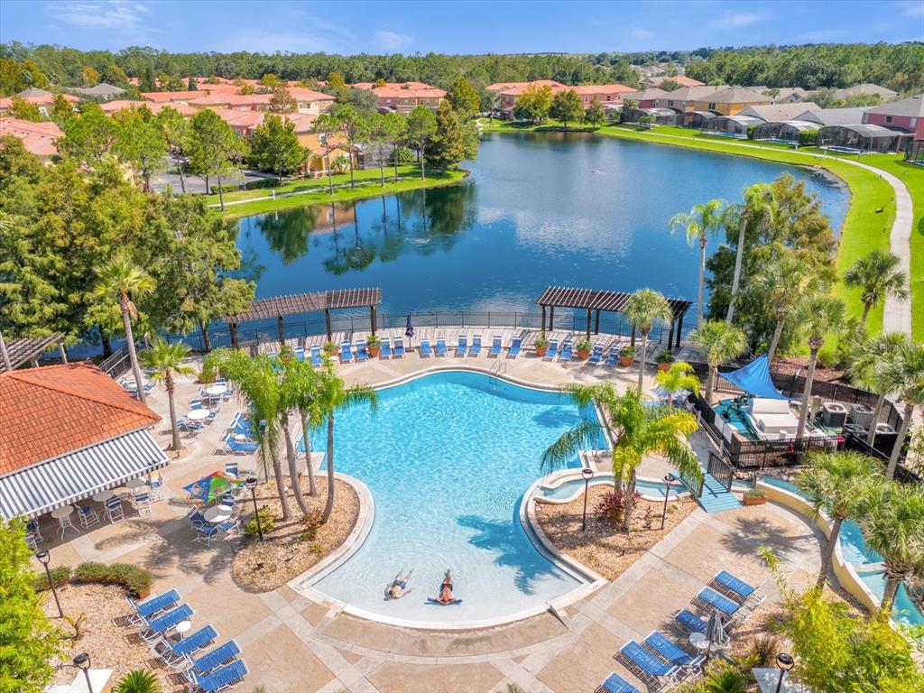 An aerial view of a swimming pool and patio area overlooking a lake and neighborhood — 164 CASTAWAY BEACH WAY, KISSIMMEE, FL