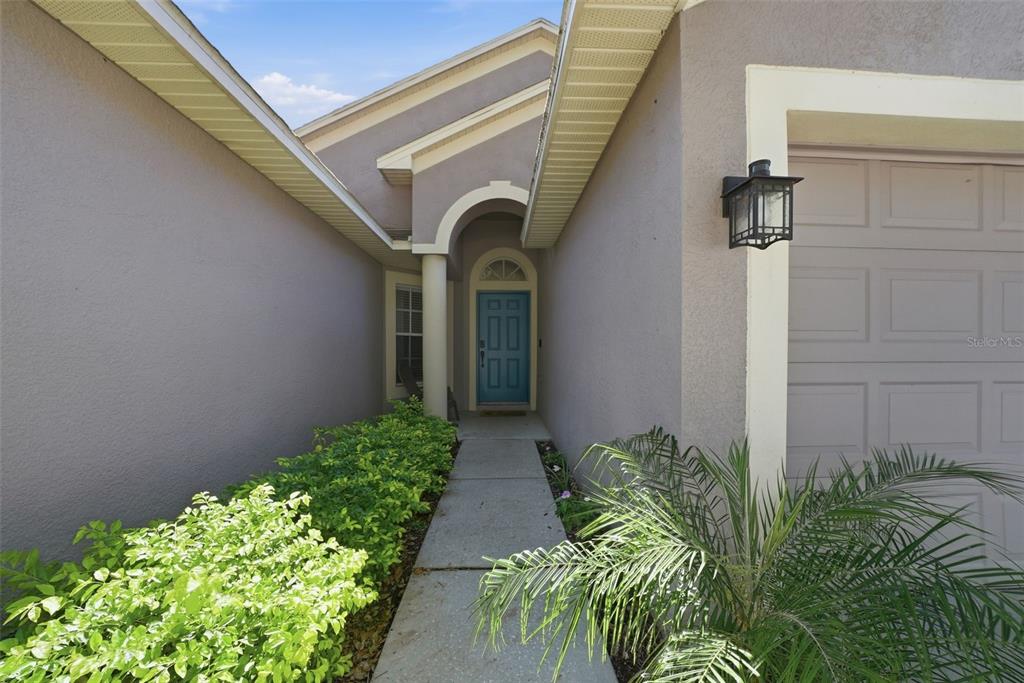 A concrete walkway leads to a blue front door under a covered entryway — 3511 GRAY WHETSTONE STREET, BRANDON, FL