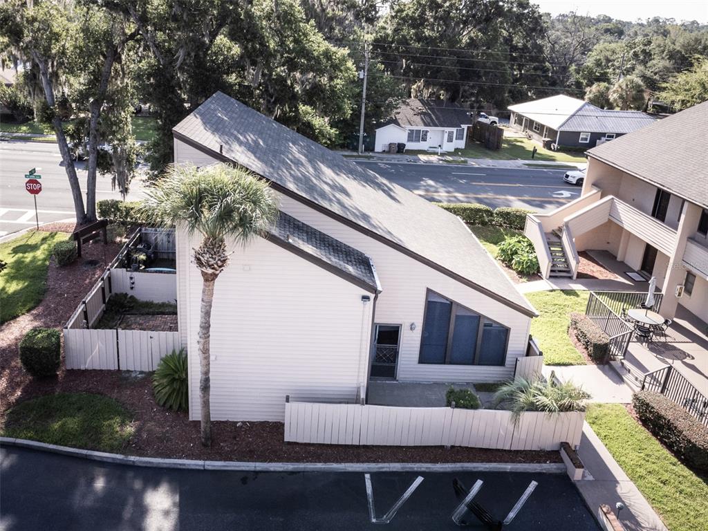 An aerial view of a tan, multi-level residential building with a sloped roof and palm tree — 2446 NE 7TH ST UNIT 57, OCALA, FL
