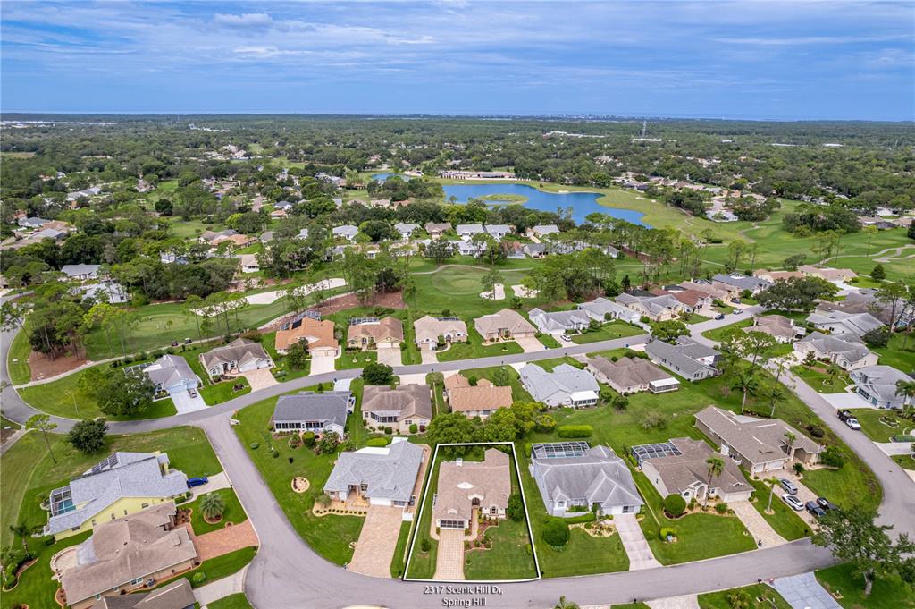An aerial view shows a single-family home with a white outline in a suburban neighborhood — 2317 SCENIC HILL DRIVE, SPRING HILL, FL