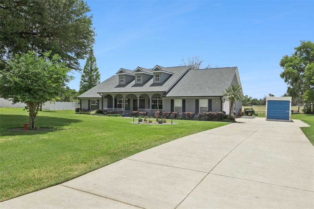 A gray single-story house with three dormers and a long concrete driveway — 31038 FAIRVISTA DRIVE, TAVARES, FL