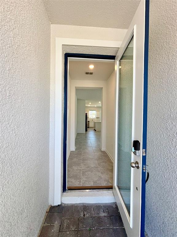 An open front door reveals a tiled entryway leading into a bright, open-concept home interior — 164 BOGEY DRIVE, DAVENPORT, FL