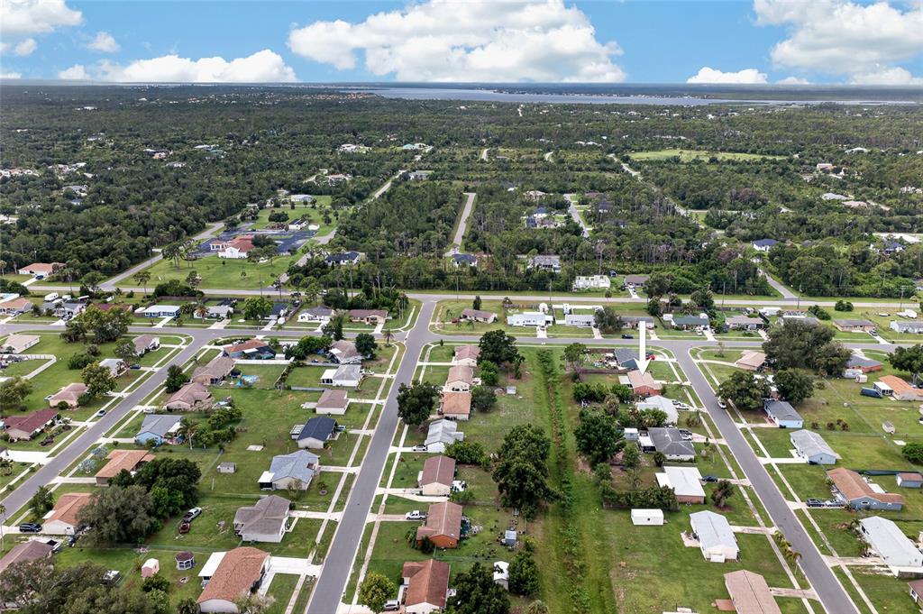 An aerial view shows a suburban neighborhood with a white arrow pointing to a specific house — 7582 LYNCREST STREET, NORTH PORT, FL