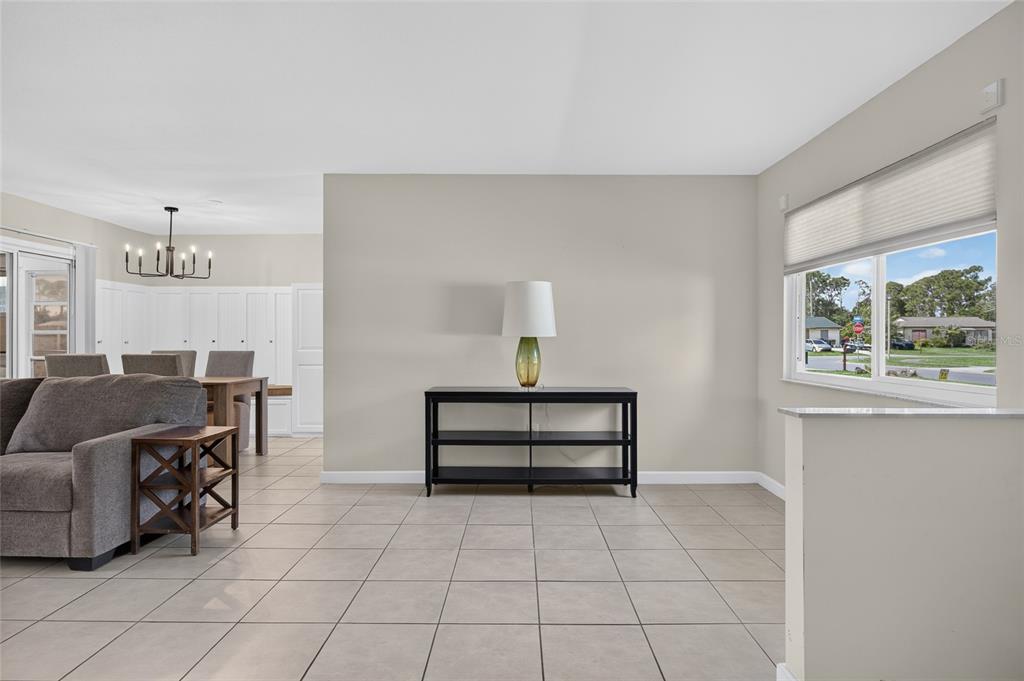 A living room with tile flooring, a black console table, and a view of the street — 7582 LYNCREST STREET, NORTH PORT, FL