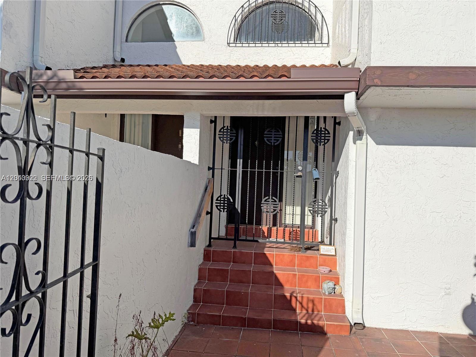 The exterior entrance features a tiled staircase, a metal security gate, and arched windows above — 1331 SW 124th Ct # 3, Miami FL 33184, MIAMI, FL