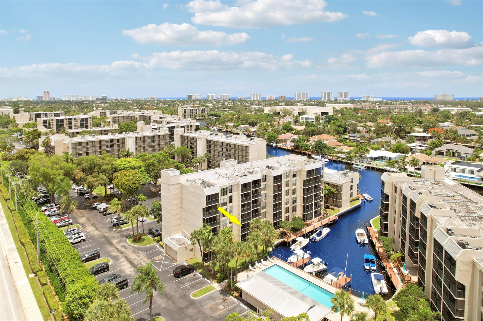An aerial view shows a multi-story apartment complex with a pool and boat slips — 20 Royal Palm Way # 204, Boca Raton FL 33432, BOCA RATON, FL