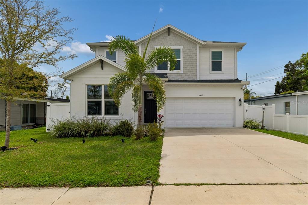 A two-story house with a white stucco facade, a two-car garage, and a palm tree — 3920 W LEMON STREET, TAMPA, FL