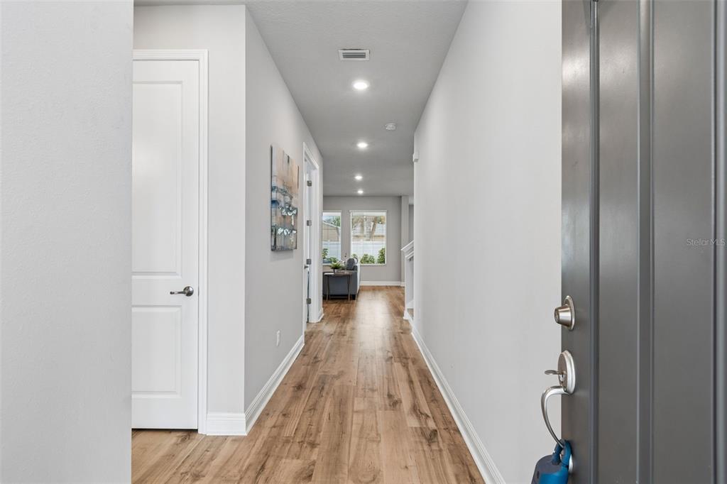 A view from an entryway down a hallway with wood-look flooring toward a living area — 3920 W LEMON STREET, TAMPA, FL