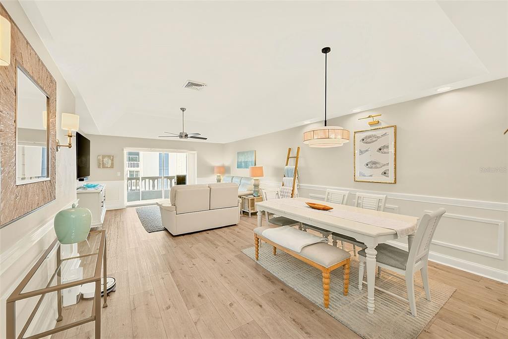 A bright open-concept living and dining area features light wood flooring and neutral walls — 147 BLUFF VIEW DRIVE UNIT 304, LARGO, FL