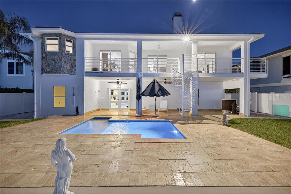 A two-story house exterior features a swimming pool, a stone patio, and a spiral staircase — 5101 SOUTH SHORE DRIVE, NEW PORT RICHEY, FL