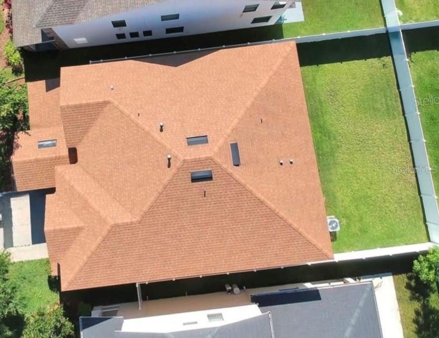 An aerial view shows the brown shingled roof of a house with several skylights — 2514 CROSS MORE STREET, VALRICO, FL