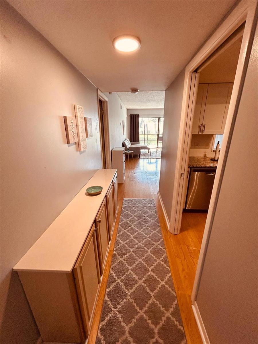 A hallway with a long console table, a patterned runner rug, and a view into a kitchen — 2050 Oleander Boulevard # 703, Fort Pierce FL 34950, FORT PIERCE, FL