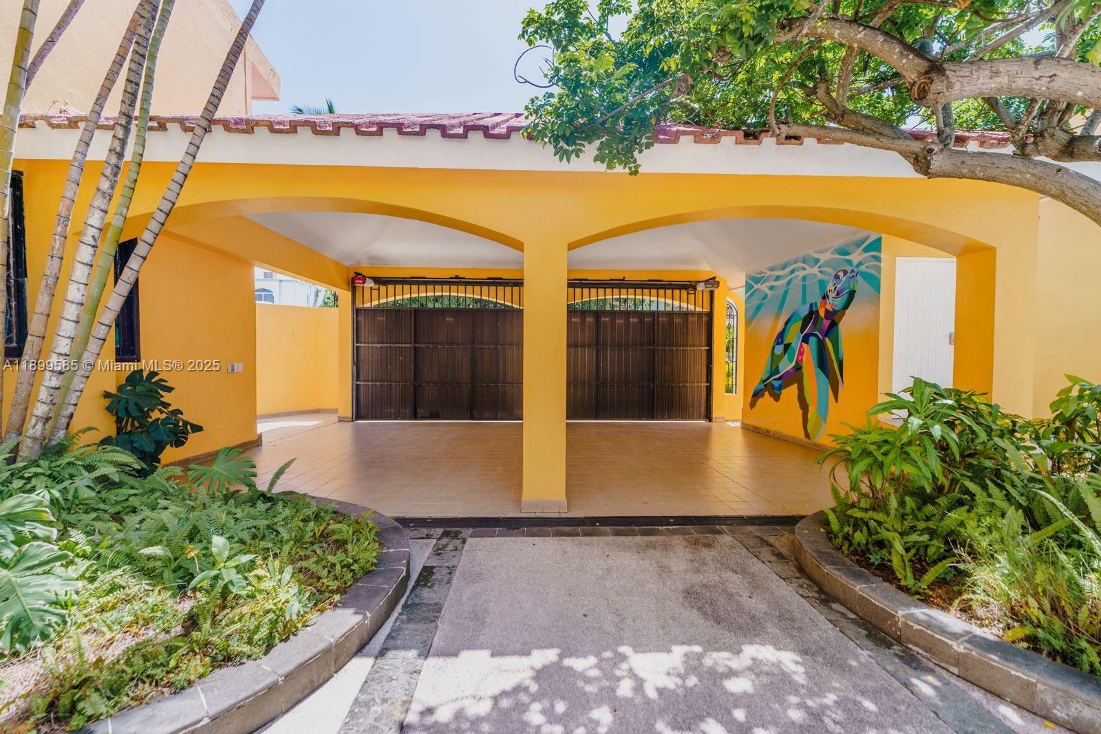 A covered carport with yellow walls, a tiled floor, and a sea turtle wall mural — 1010 La Joya, WY 82110, WY