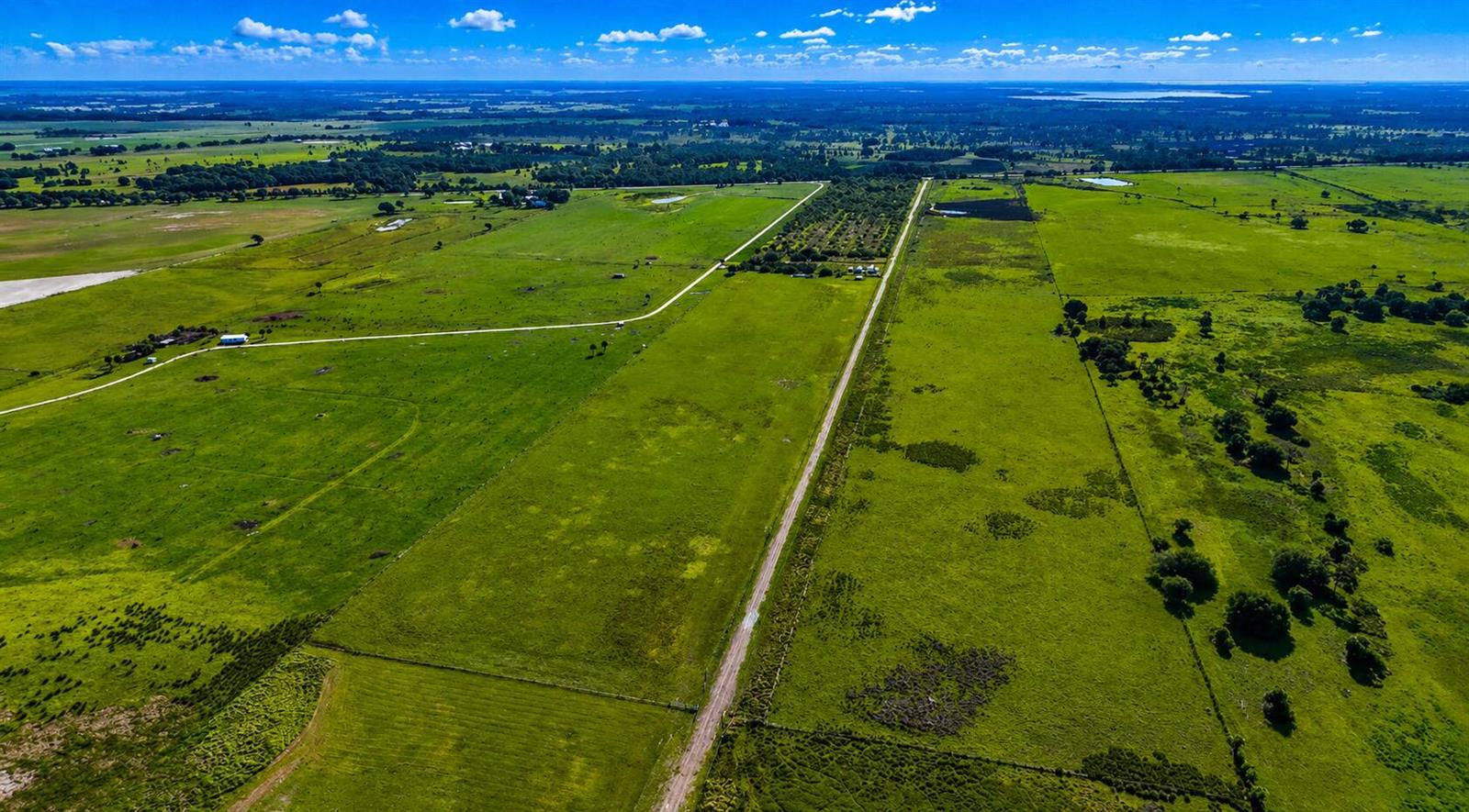 An aerial view shows a large, green rural property with dirt roads and scattered trees — Tbd Kenansville Road, FL 34739, FL