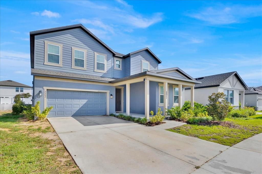 A two-story blue house with a two-car garage and a covered front porch — 2342 LANCASHIRE STREET, DAVENPORT, FL