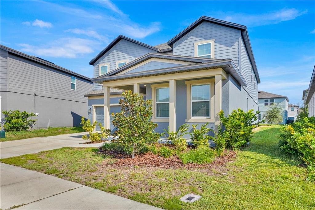 A two-story house with blue siding, a front porch, and a concrete driveway — 2342 LANCASHIRE STREET, DAVENPORT, FL