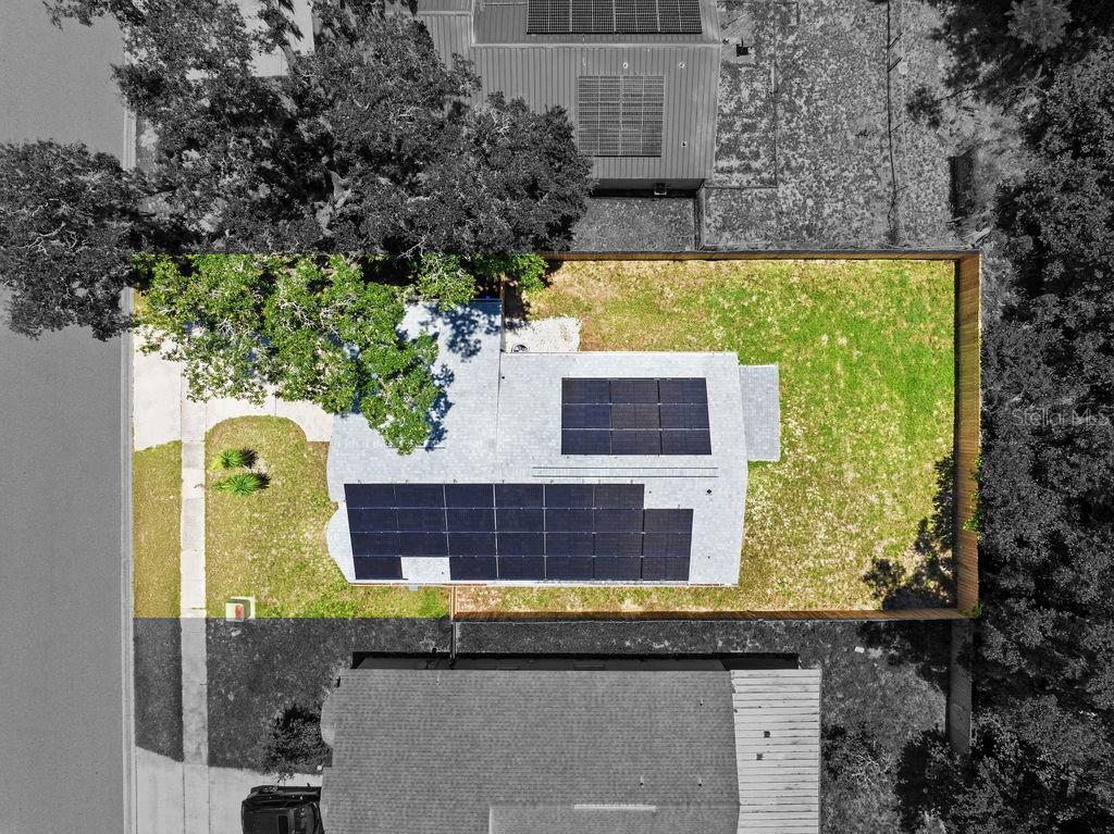 An aerial view of a residential house with solar panels on the roof and a backyard — 6330 RUTHIE DRIVE, ORLANDO, FL