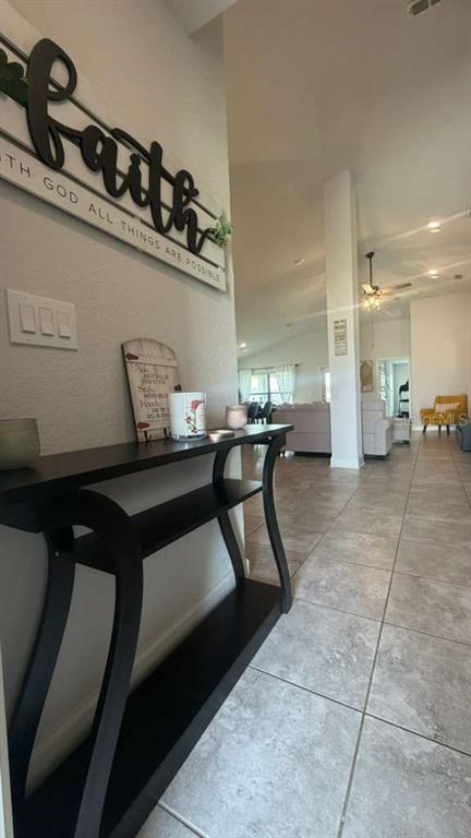 A black console table sits in a tiled entryway leading to an open-concept living area — 365 CITRUS POINTE DRIVE, DAVENPORT, FL