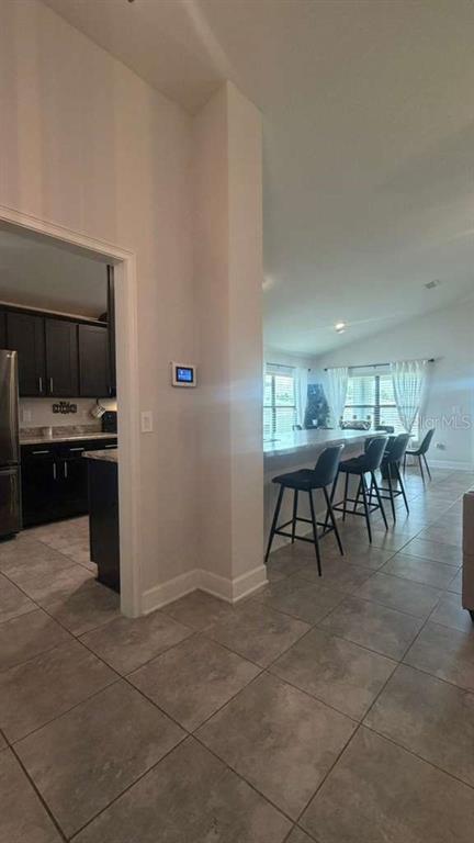 A view from a tiled room looking into a kitchen and a breakfast bar area — 365 CITRUS POINTE DRIVE, DAVENPORT, FL