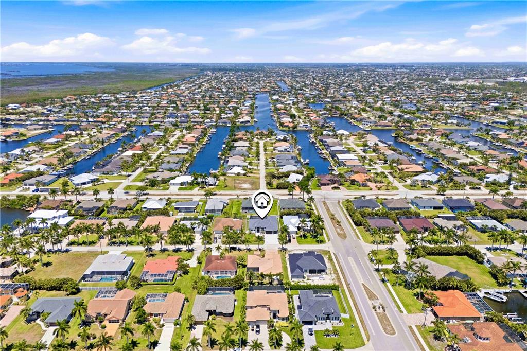 An aerial view shows a residential neighborhood with houses, canals, and palm trees — 2739 SW 42ND LANE, CAPE CORAL, FL