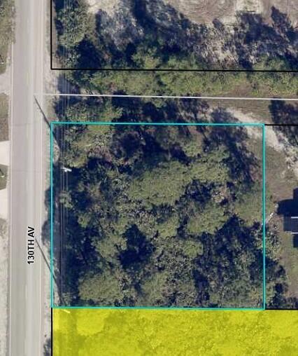 An aerial view shows a rectangular, tree-covered vacant lot bordered by a road — 8590 130th Avenue, Fellsmere FL 32948, FELLSMERE, FL