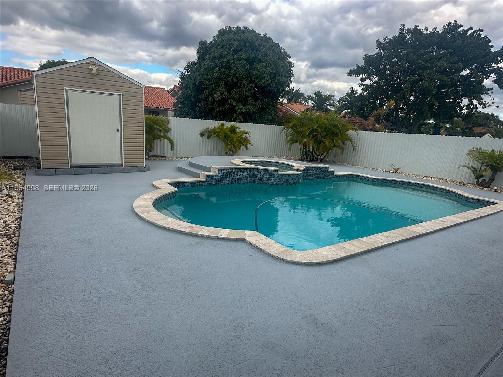 A backyard features a swimming pool with a raised spa, a storage shed, and fencing — 14759 SW 82nd St, Miami FL 33193, MIAMI, FL