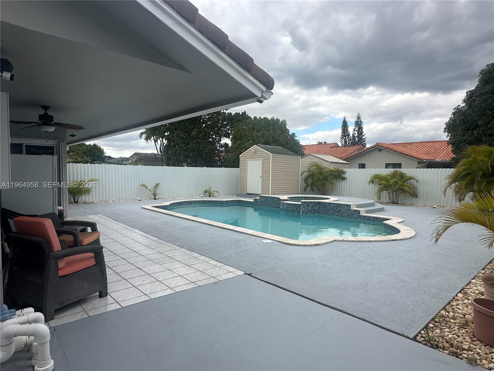 A backyard features a swimming pool with a spa, a storage shed, and patio furniture — 14759 SW 82nd St, Miami FL 33193, MIAMI, FL