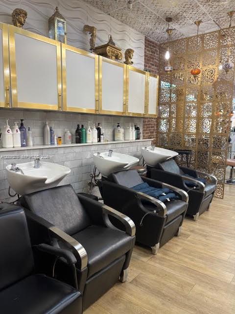 A hair salon features three black shampoo chairs with white basins and gold-trimmed cabinetry — FL-7, Boca Raton FL 33428, BOCA RATON, FL