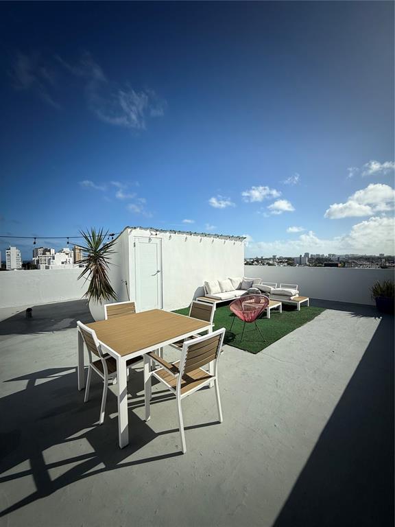 A rooftop terrace features a dining set, lounge seating on a rug, and city views — 171 CALLE SAN JORGE UNIT Ph702, SAN JUAN, PR