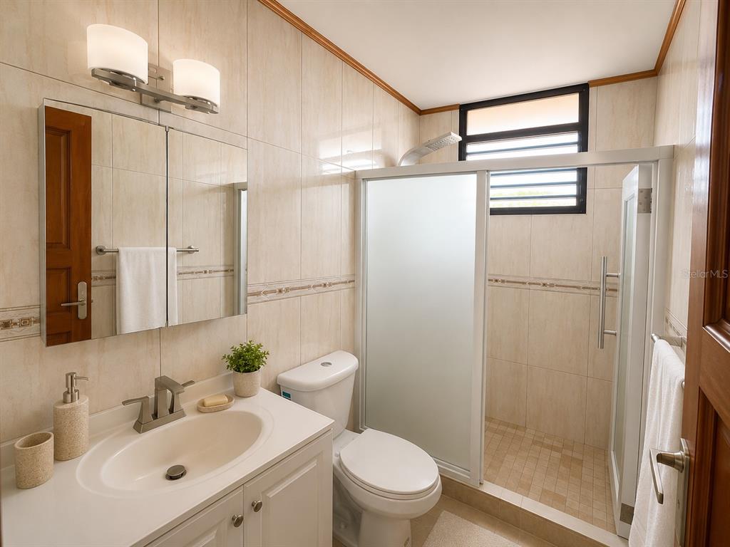 A bathroom features a vanity with a sink, a toilet, and a glass-enclosed shower stall — 171 CALLE SAN JORGE UNIT Ph702, SAN JUAN, PR