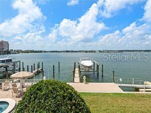 A view of a boat dock and a small boat on a calm body of water — 17735 GULF BOULEVARD UNIT 204, REDINGTON SHORES, FL