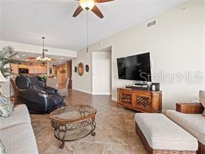 A living room features tile flooring, a television on a wooden console, and a recliner — 17735 GULF BOULEVARD UNIT 204, REDINGTON SHORES, FL
