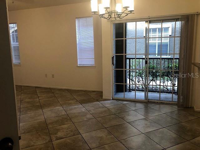 A dining area features tile flooring, a chandelier, and sliding glass doors leading to a balcony — 102 VISTA VERDI CIRCLE UNIT 112, LAKE MARY, FL