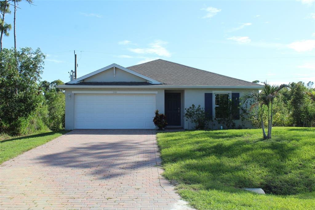 A single-story house with a paved driveway, two-car garage, and a front lawn — 5501 KEMPSON LANE, PORT CHARLOTTE, FL