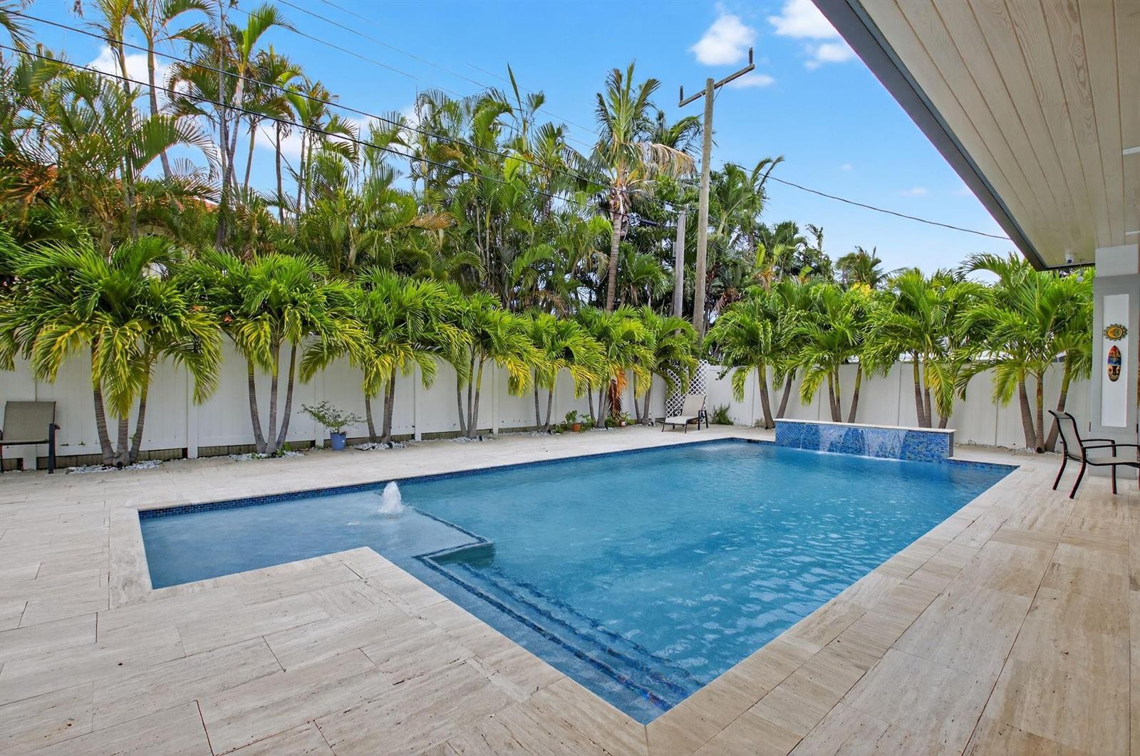 A backyard swimming pool with a fountain and waterfall feature surrounded by palm trees — 711 NE 6th Street, Boca Raton FL 33432, BOCA RATON, FL