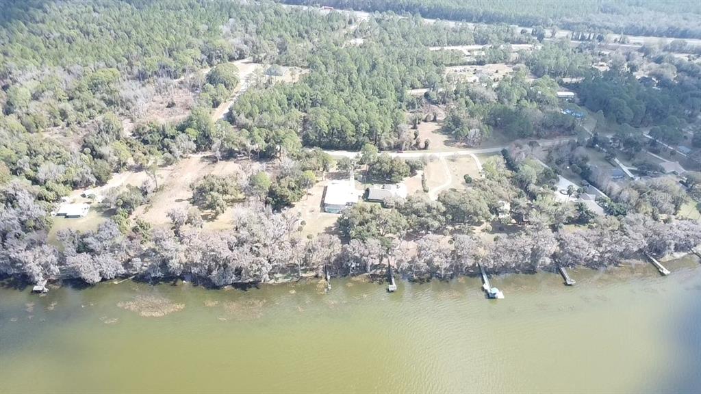 An aerial view shows several waterfront houses with private docks along a wooded shoreline — 13837 SE 201ST TERRACE, HAWTHORNE, FL