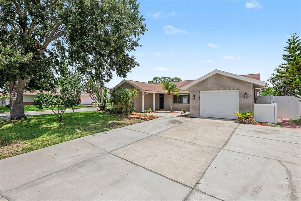 A single-story brick house with a white garage door and a concrete driveway — 3750 LIGHTHOUSE WAY, HOLIDAY, FL