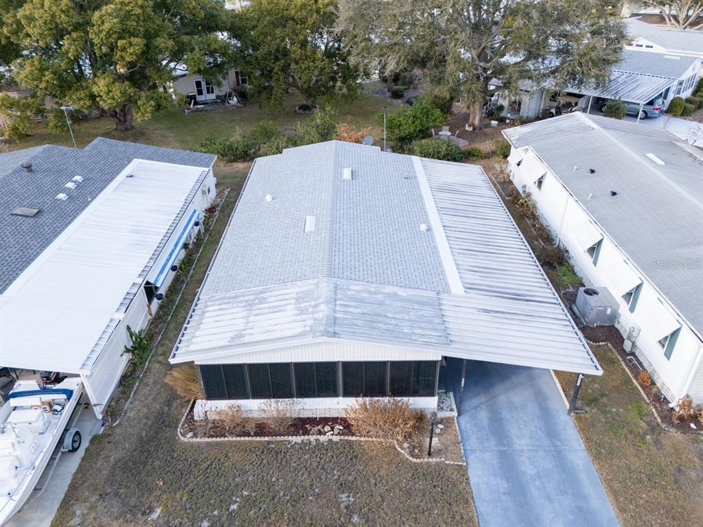 An aerial view shows a mobile home with a metal roof and an attached carport — 6081 SOUTHERN OAKS DRIVE SE, WINTER HAVEN, FL