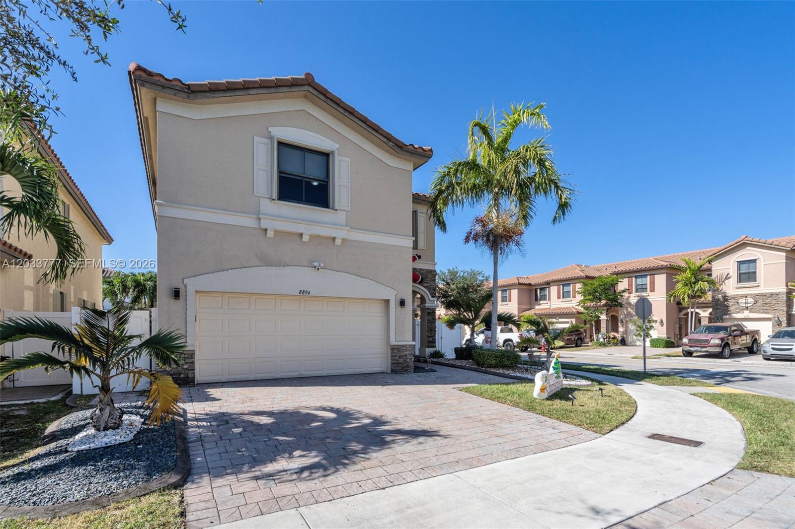 A two-story beige stucco house features a two-car garage and a paved driveway — 8894 W 34th Ave, Hialeah FL 33018, HIALEAH, FL
