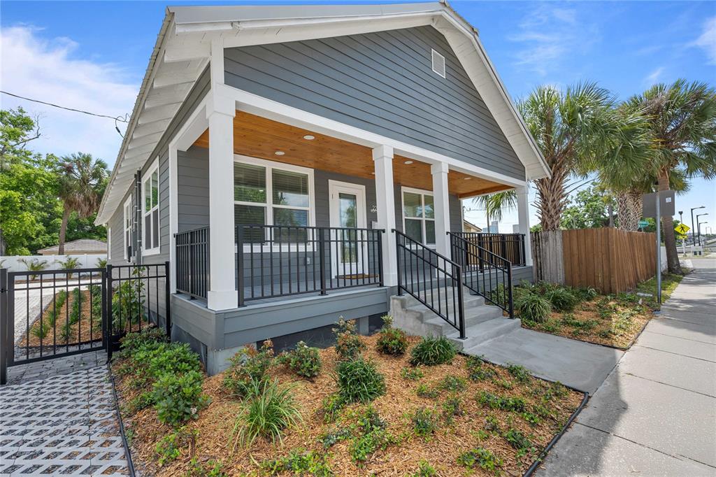 A gray house with a covered front porch, white columns, and a landscaped front yard — 2203 N BOULEVARD, TAMPA, FL