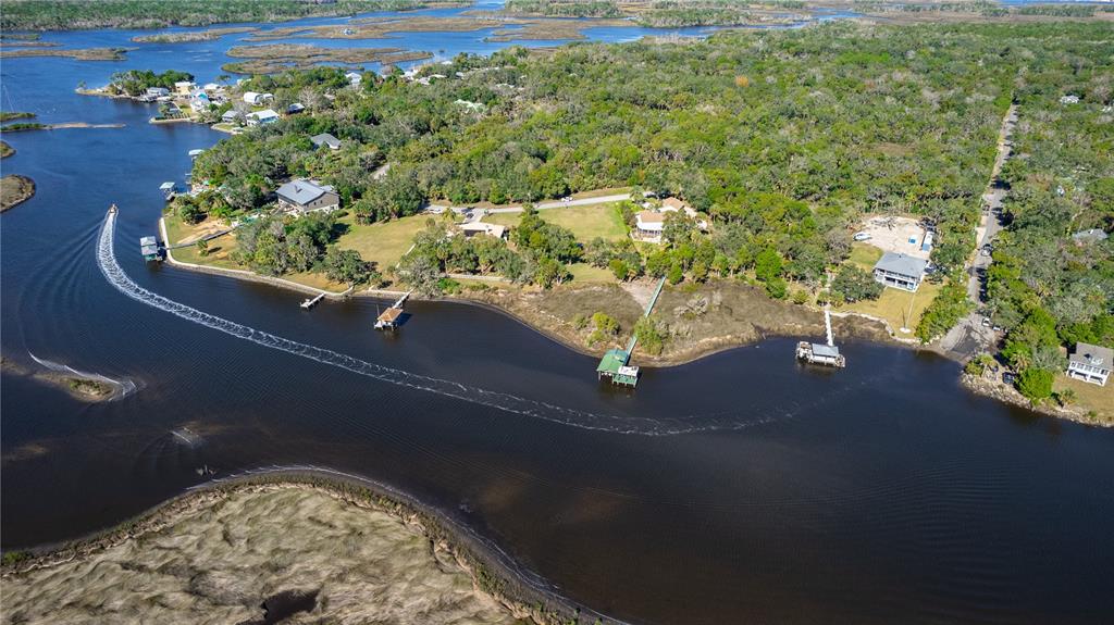 An aerial view shows waterfront homes with private docks along a winding river and marsh — 12214 W RESTVIEW COURT, HOMOSASSA, FL
