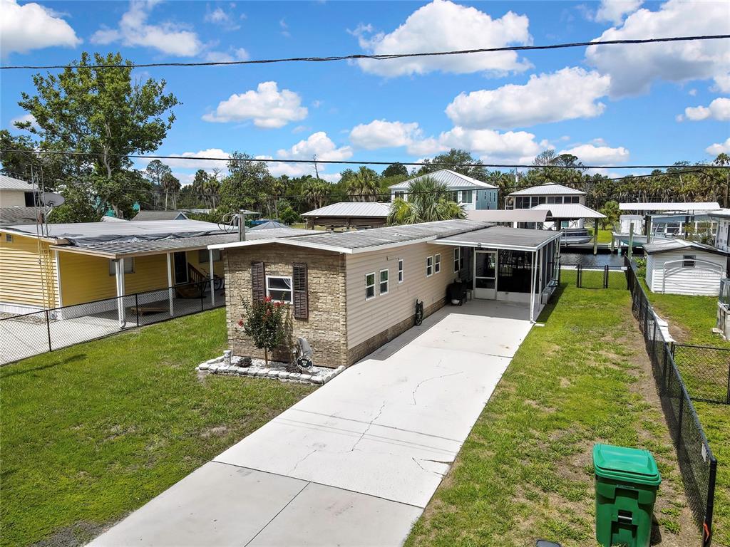 An aerial view shows a mobile home with a stone facade, driveway, and screened porch — 2630 N COMANCHE POINT, CRYSTAL RIVER, FL