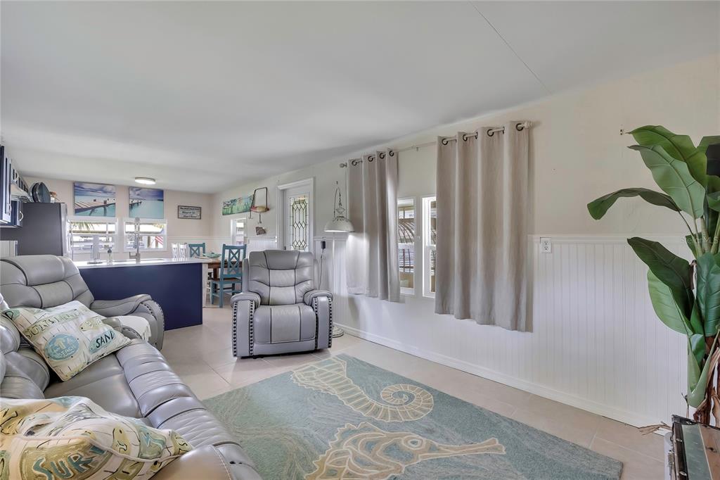 A living room features a gray leather sofa, a matching recliner, and a seahorse-patterned rug — 2630 N COMANCHE POINT, CRYSTAL RIVER, FL