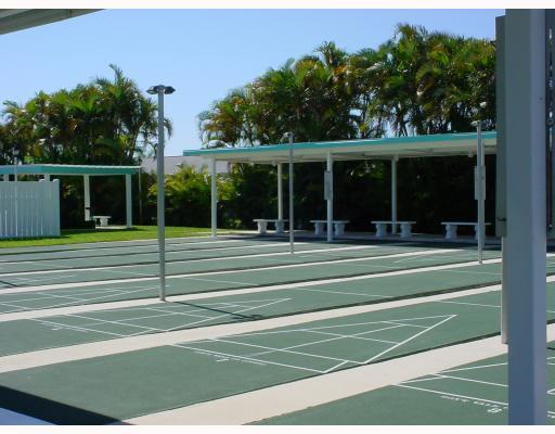Outdoor shuffleboard courts with covered seating areas and palm trees in the background — 2556 E Dudley Dr Drive E # D, West Palm Beach FL 33415, WEST PALM BEACH, FL