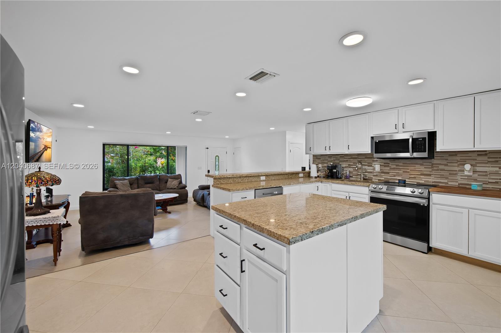 A single-story house with a large flowering tree in the front yard — 6839 Tradewind Way, Lake Worth FL 33462, LAKE WORTH, FL