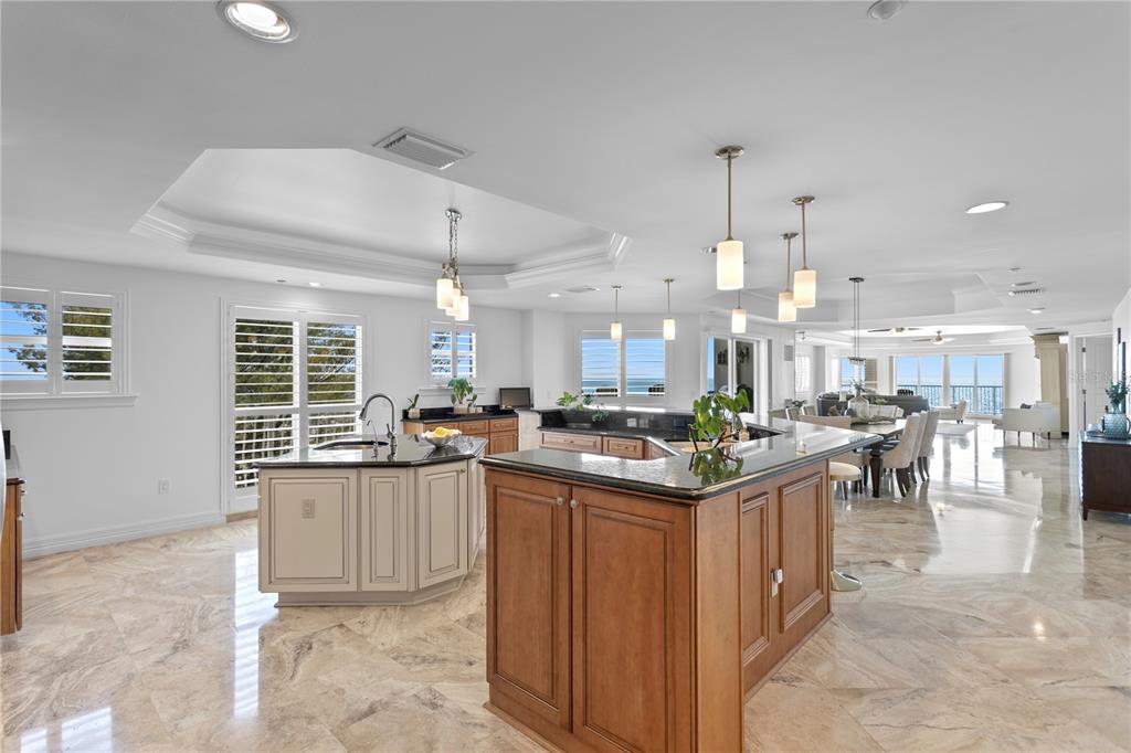 A spacious kitchen features two islands, granite countertops, and light-colored tile flooring — 19730 GULF BOULEVARD UNIT 400, INDIAN ROCKS BEACH, FL