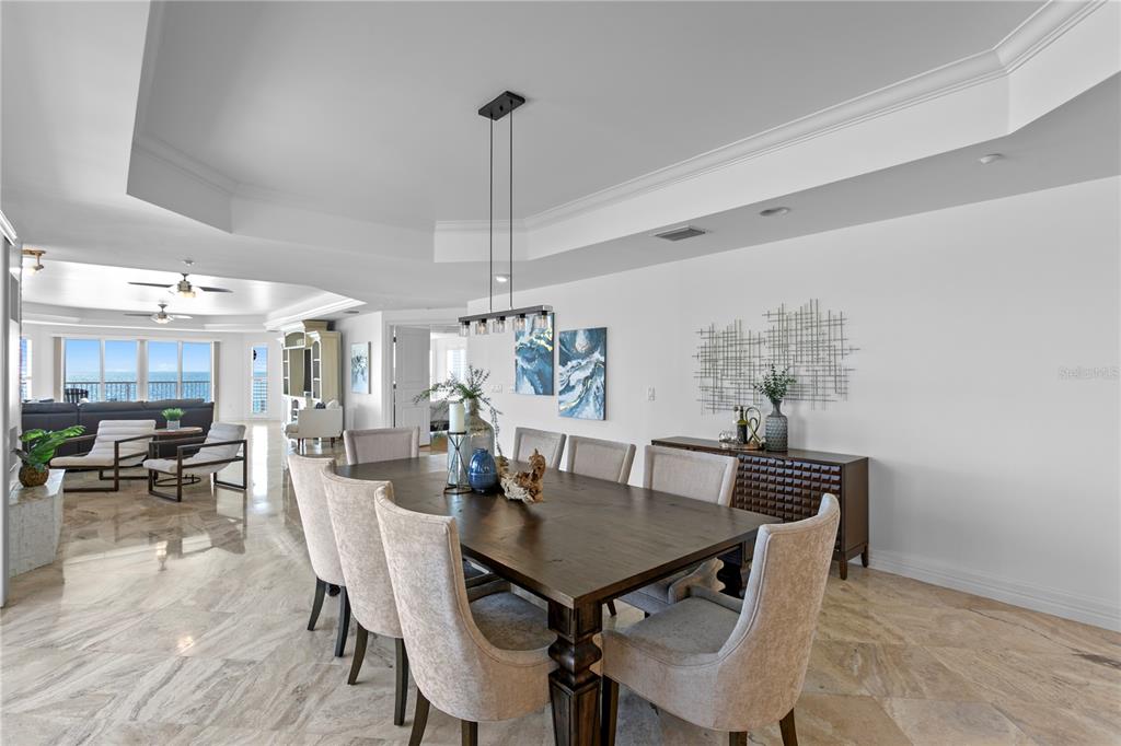A dining room features a wooden table, upholstered chairs, and marble flooring — 19730 GULF BOULEVARD UNIT 400, INDIAN ROCKS BEACH, FL