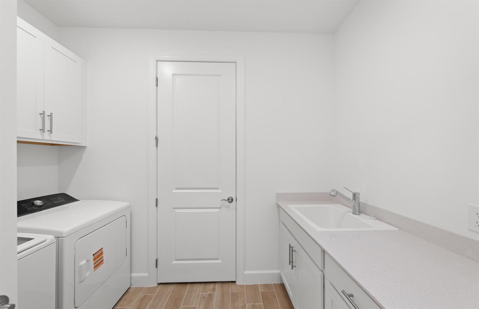 A laundry room with white cabinets, a utility sink, and a white washer and dryer — 12584 Quartz Drive, FL 33920, FL