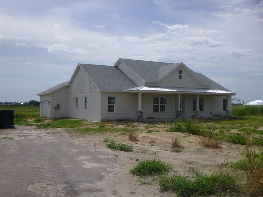 A newly constructed, single-story house with light siding and a covered front porch — 2975 PIT ROAD, BARTOW, FL