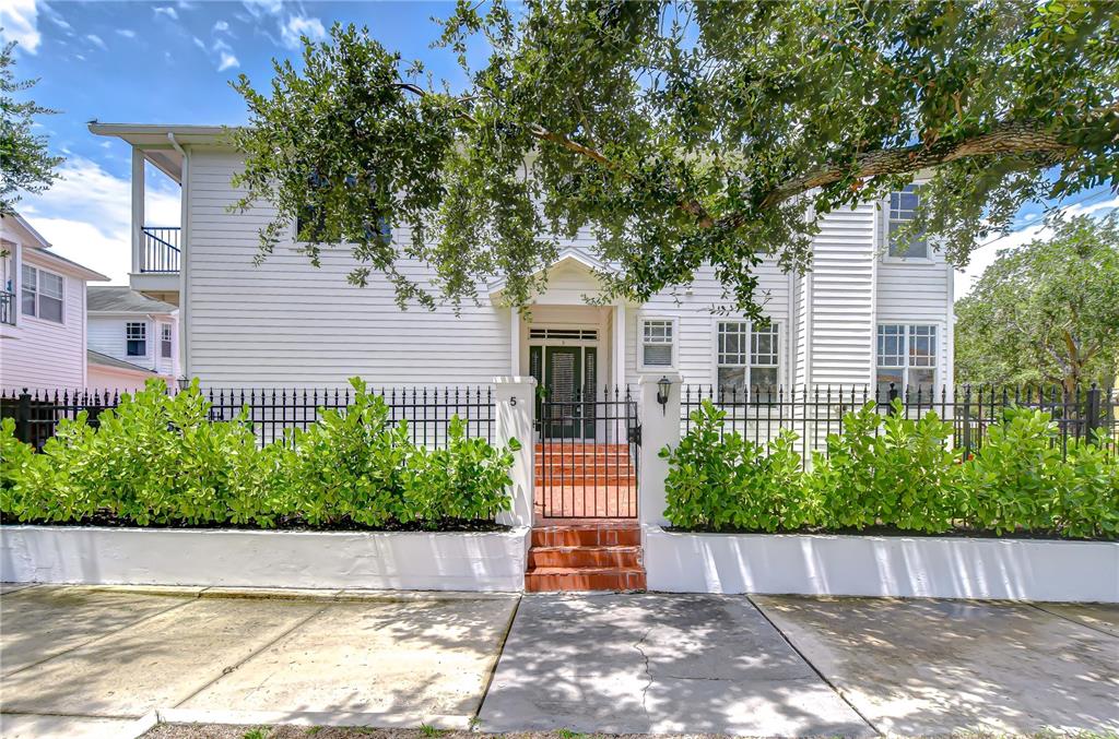 A white two-story house features a gated brick entrance and a manicured hedge — 113 BOSPHOROUS AVENUE UNIT 5, TAMPA, FL